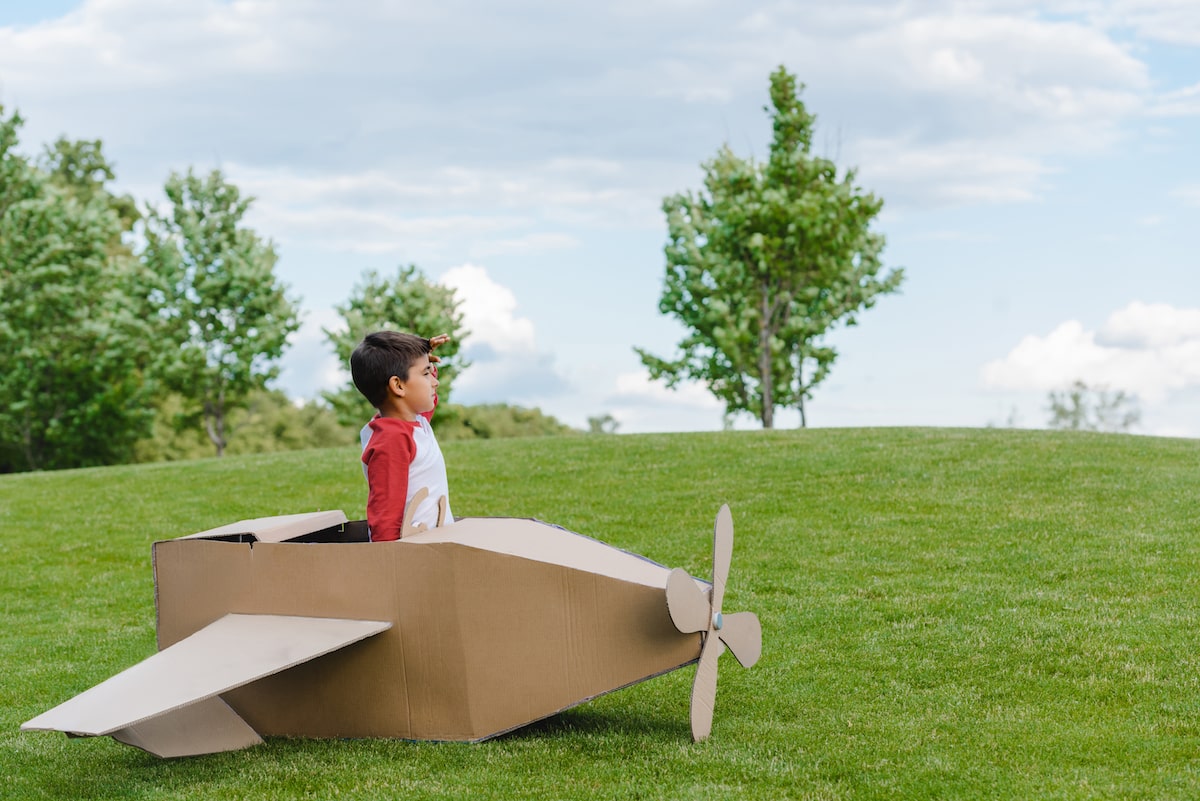 kid in cardboard plane